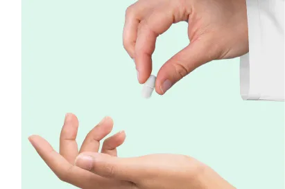 Mão de um médico dando um comprimido na mão de um paciente