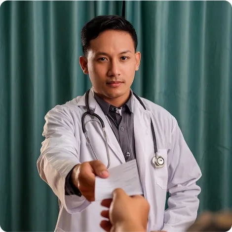 Um médico segurando uma prescrição medicamentosa em direção ao paciente.